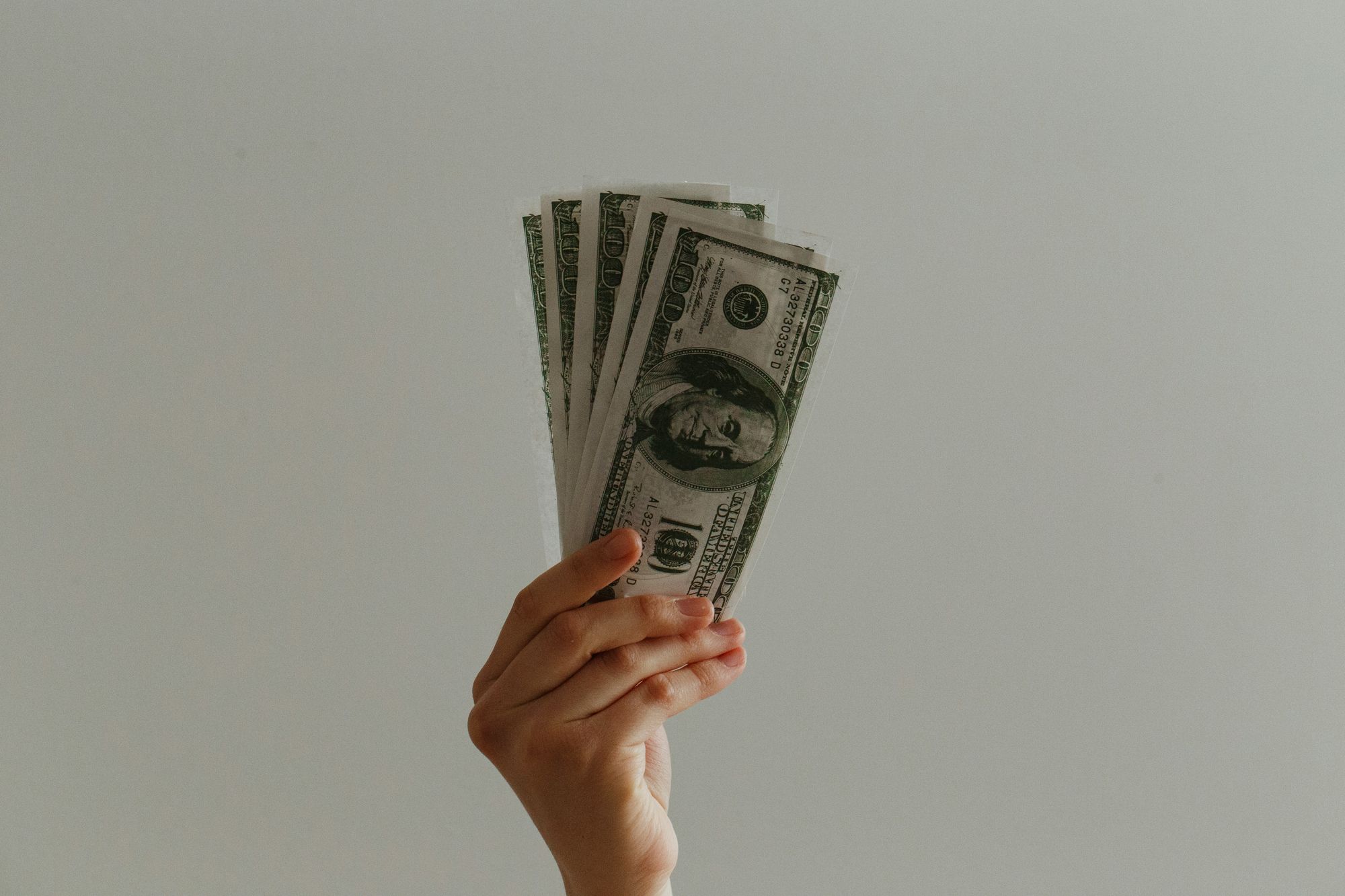 person holding money - Wellsaid Labs Pricing